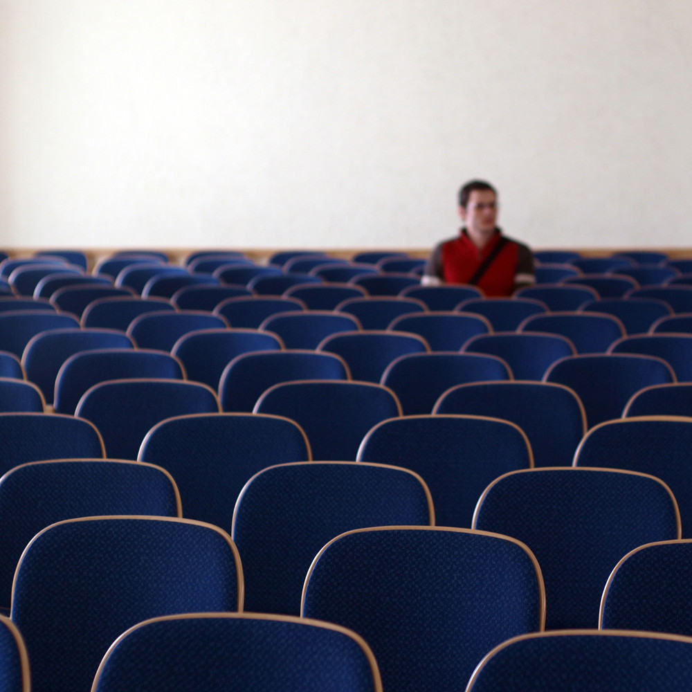Mann sitzt im leeren Hörsaal